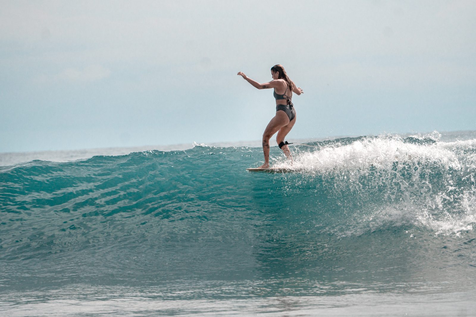 Longboarder trimming along a wave